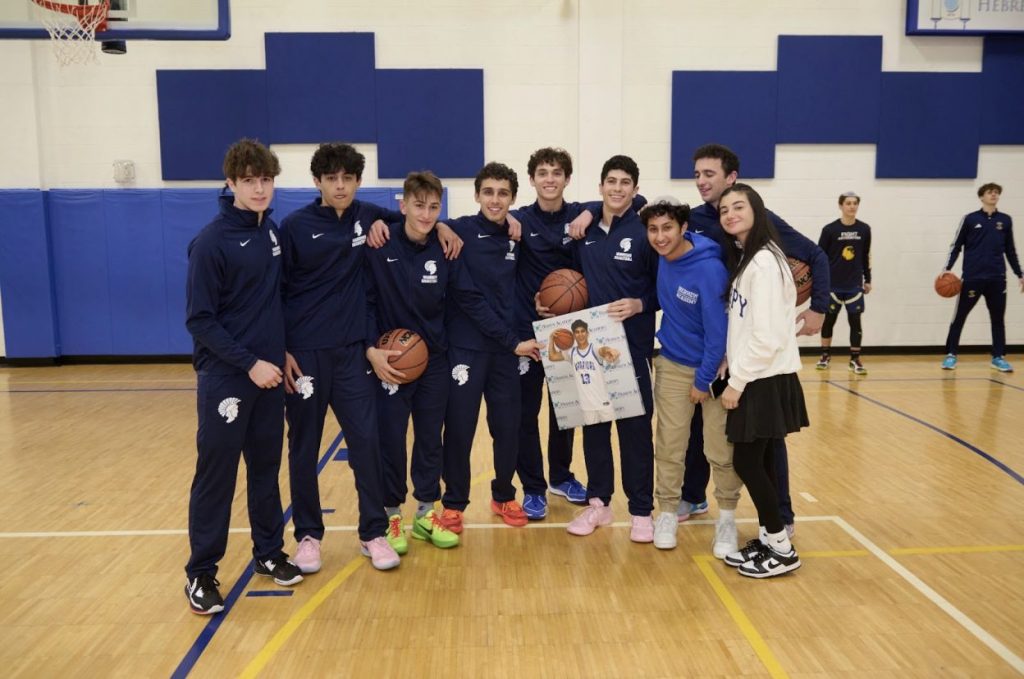 Basketball team posing happily for a group photo.