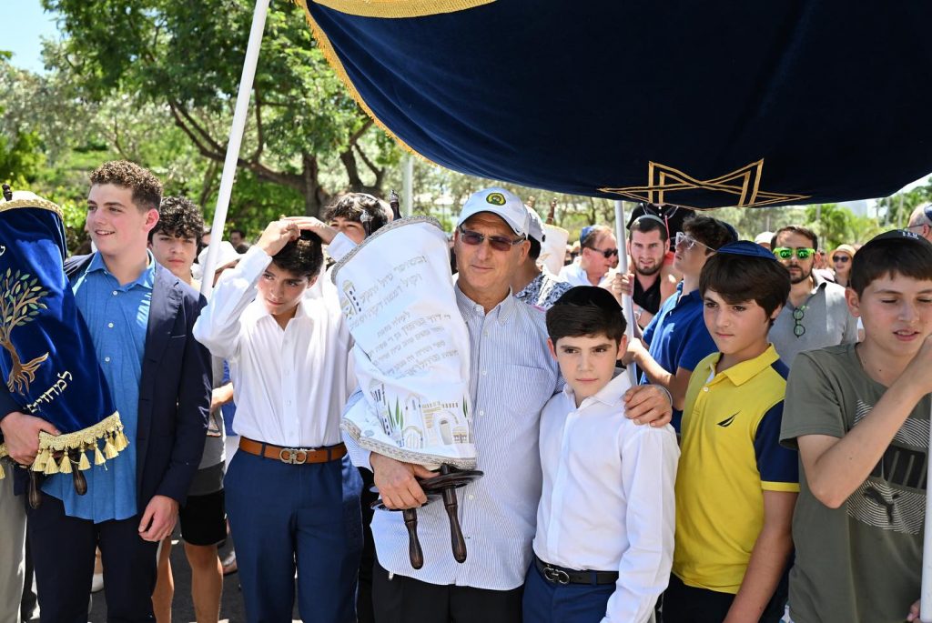 Jewish parents and students sharing smiles in a vibrant outdoor setting.