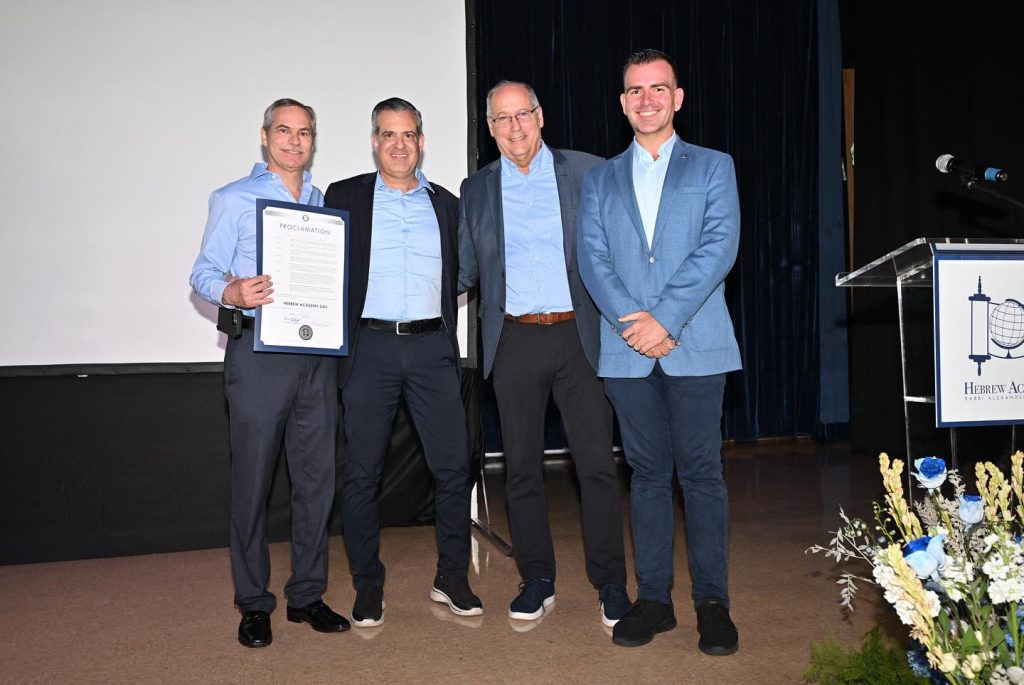 Four adults happily posing at the Hebrew Academy opening.