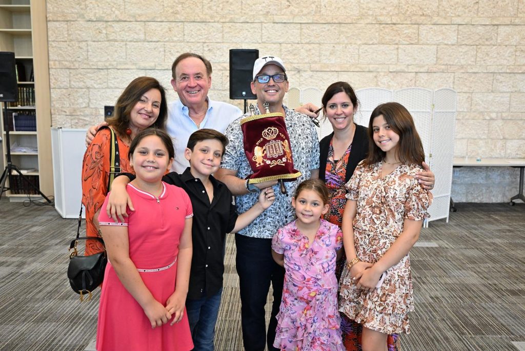 Parents, students, and their teacher smiling together at Hebrew Academy.