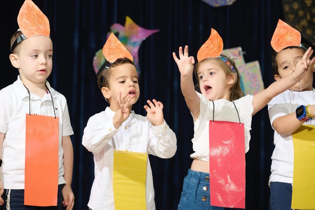 Happy children singing in a close-up photo during a school performance.