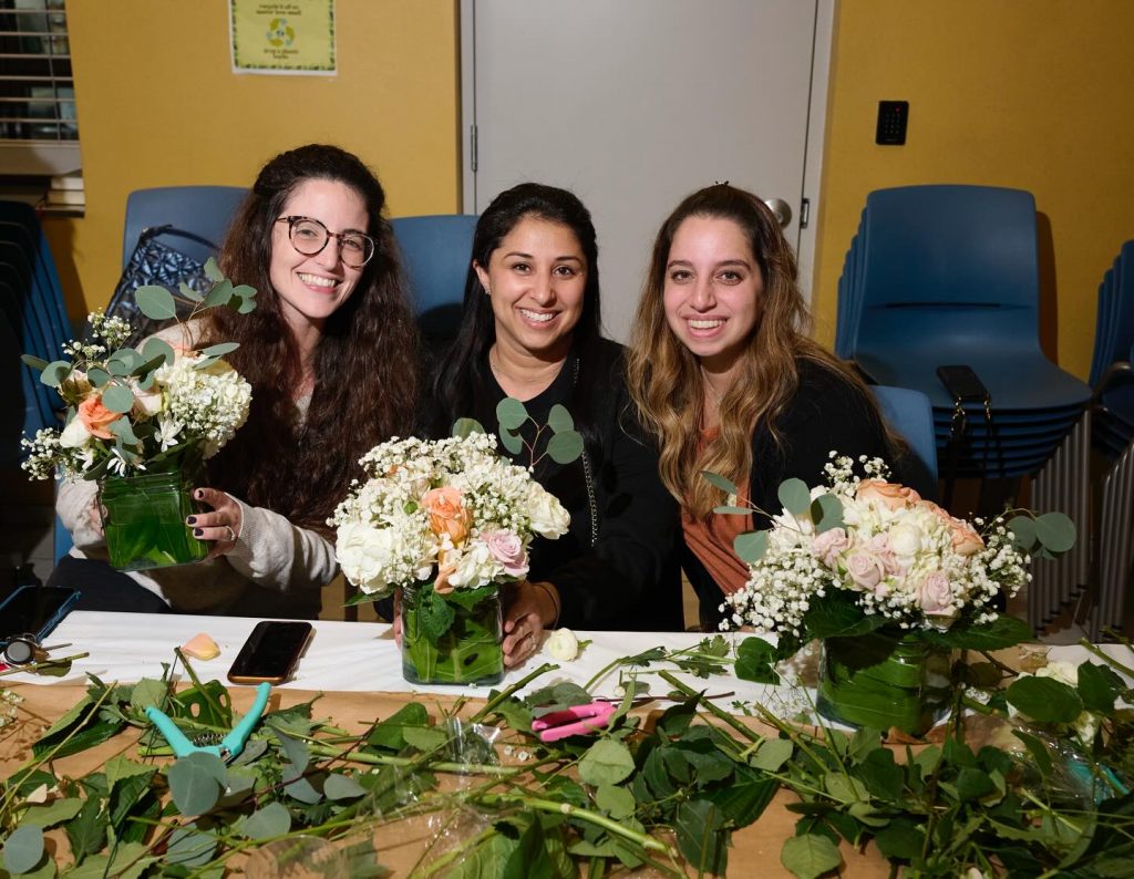 Three women participating in a flower workshop.