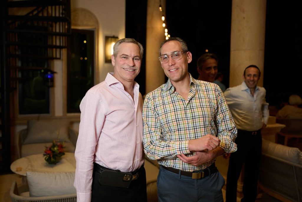 Close-up of two adults smiling for a photo at an outdoor evening event.