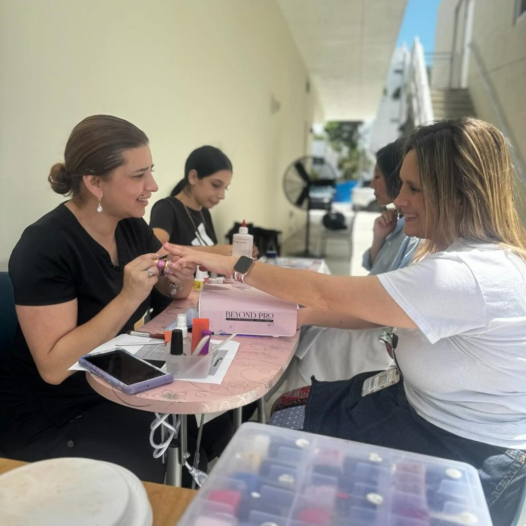 Two women enjoying a manicure during Hebrew Academy's Teacher Appreciation Week.