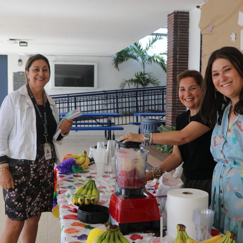 Three women happily making smoothies during Hebrew Academy's Teacher Appreciation Week.