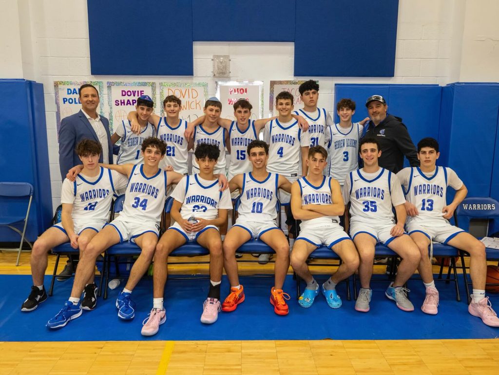 Basketball team in Warriors shirts and uniforms posing together, showcasing team spirit.