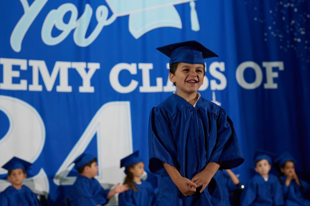 Smiling and happy boy dressed as a small graduate.