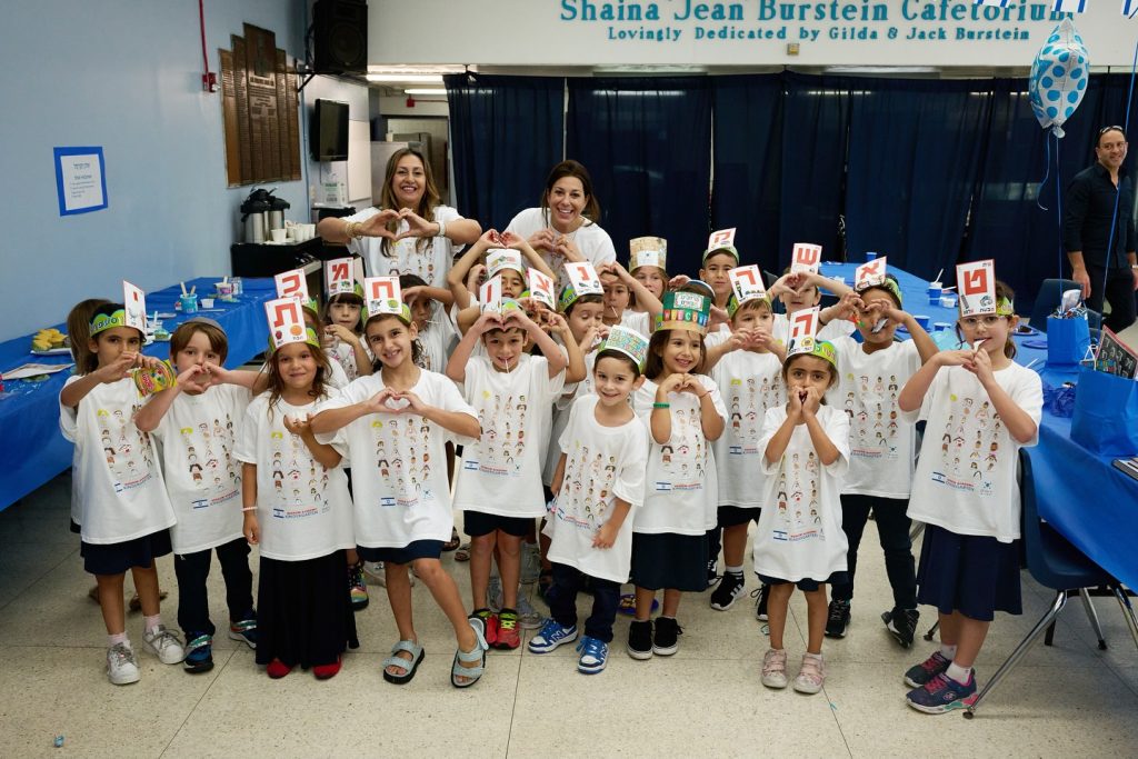 Two teachers with smiling children at Hebrew Academy, highlighting a joyful learning environment.