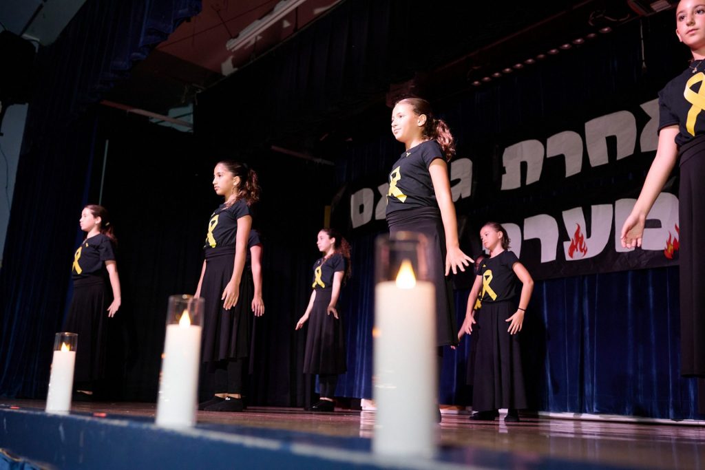 Girls dancing on a dance floor at an event, with their hands down.