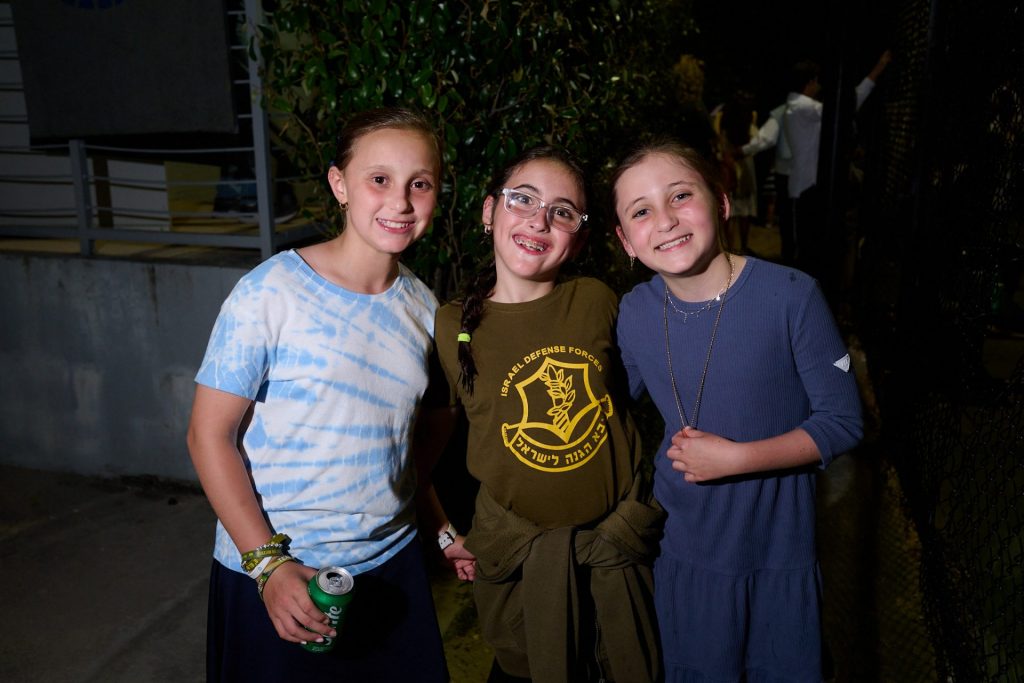 Three girls smiling and posing for a photo at a party.