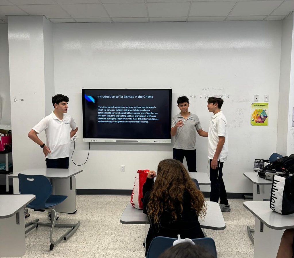 Three Hebrew Academy students presenting their project in a classroom.