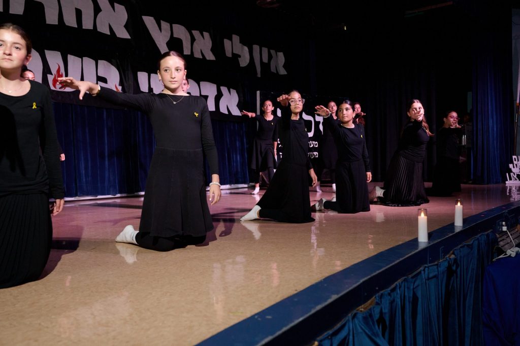 Girls dancing at an event, using their right hand to point as part of their dance routine.